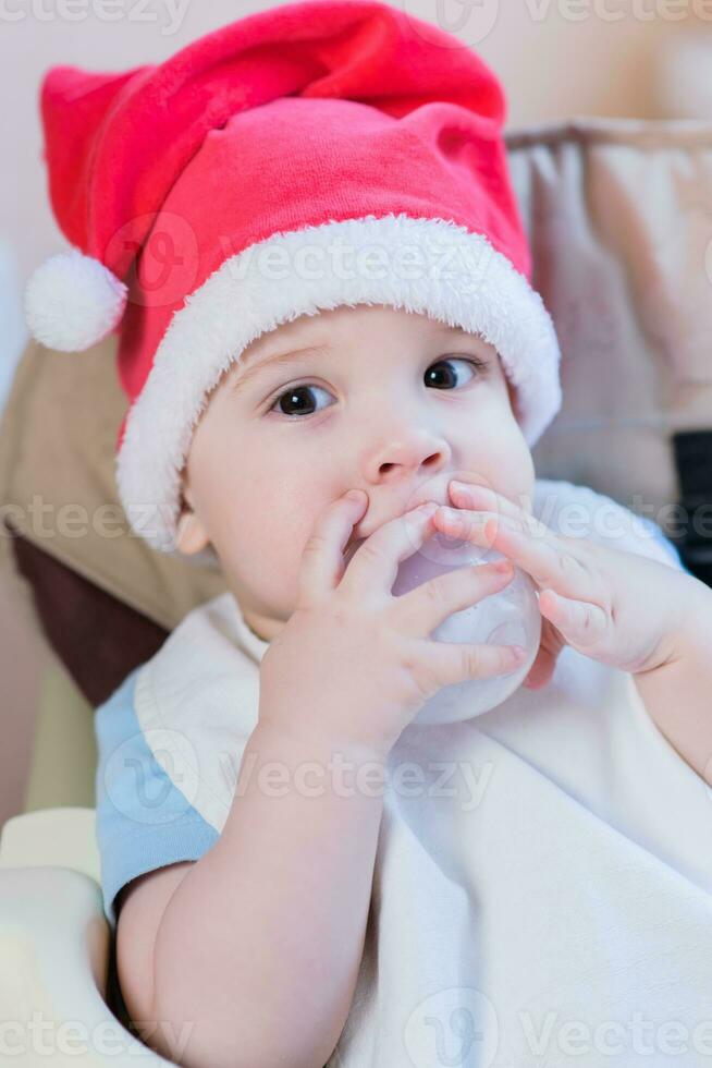 baby drinken melk in Kerstmis rood hoed foto