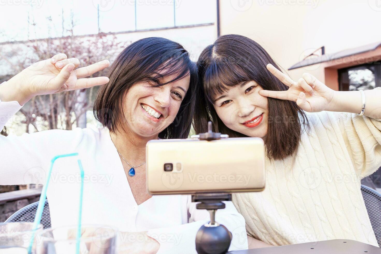 jong vrouw vrienden nemen een selfie gedurende een buitenshuis aperitief foto