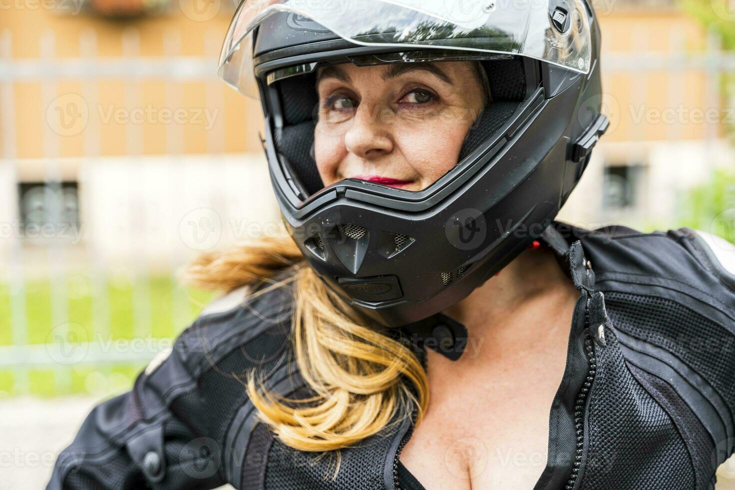 portret van volwassen vrouw met motorfiets helm buitenshuis foto