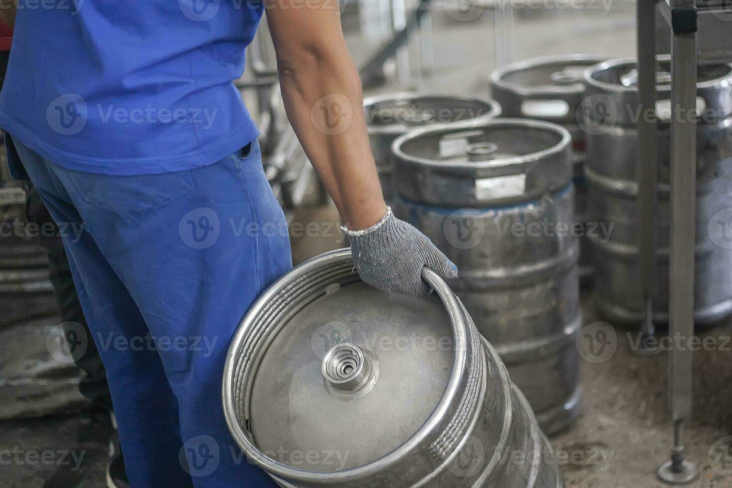 Mens zetten bier vaatjes Aan de productie lijn in de fabriek foto