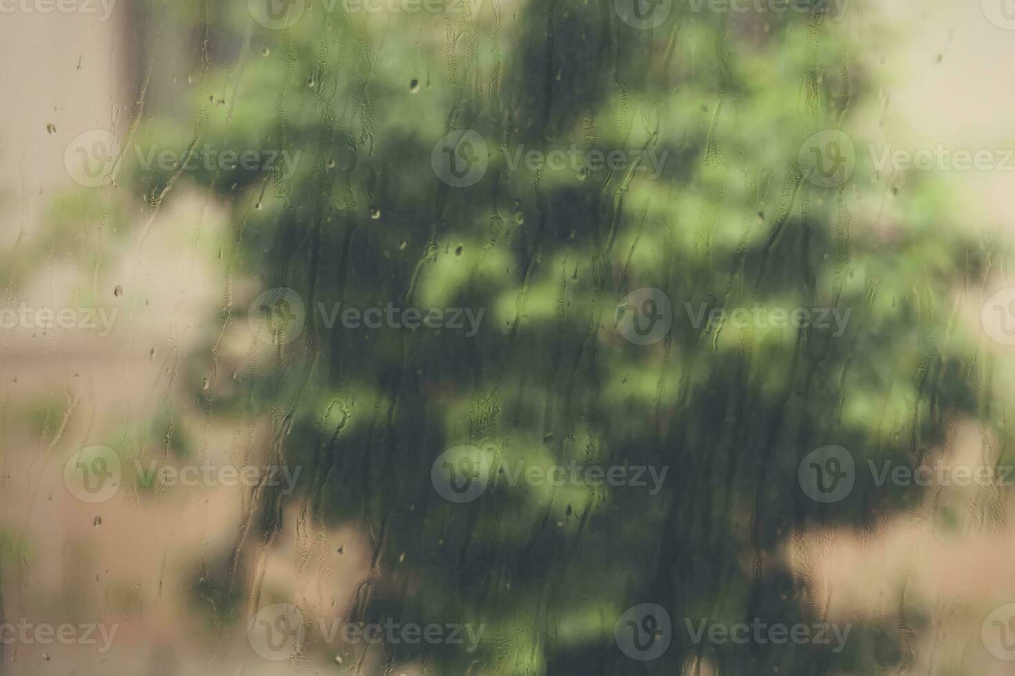 visie naar regenen weer door de huis venster. regendruppels Aan de venster glas. zwaar regenen buitenshuis. voorjaar regen seizoen foto