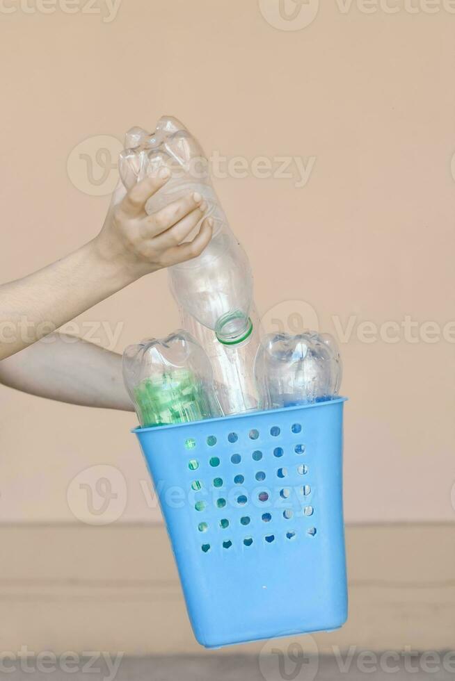 plastic vervuiling. vrouw verzameld plastic flessen en Holding recycling bak. vrij ruimte foto