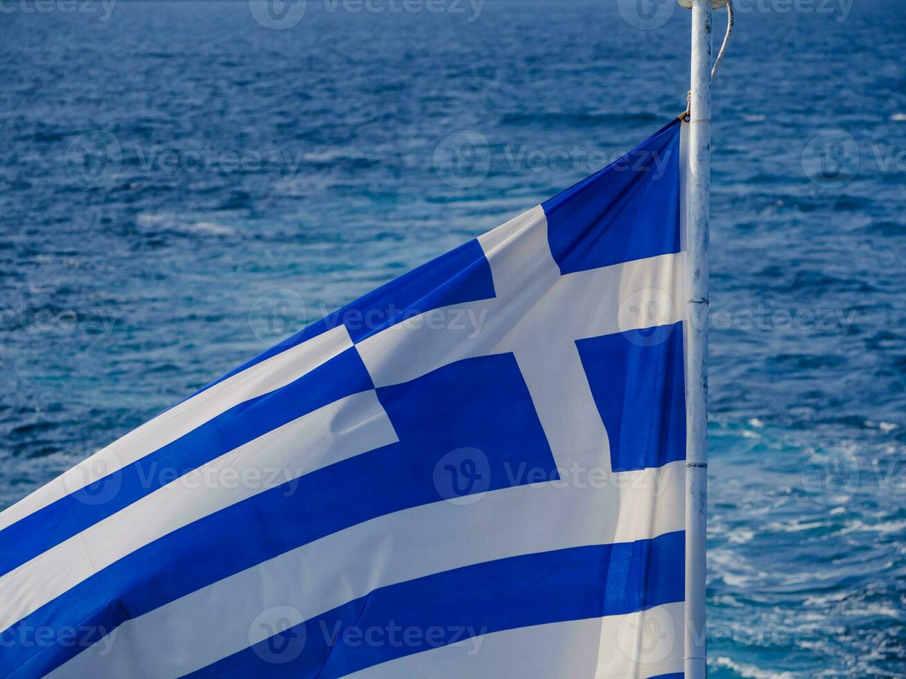 Grieks vlag in de wind en mooi zee in de achtergrond foto