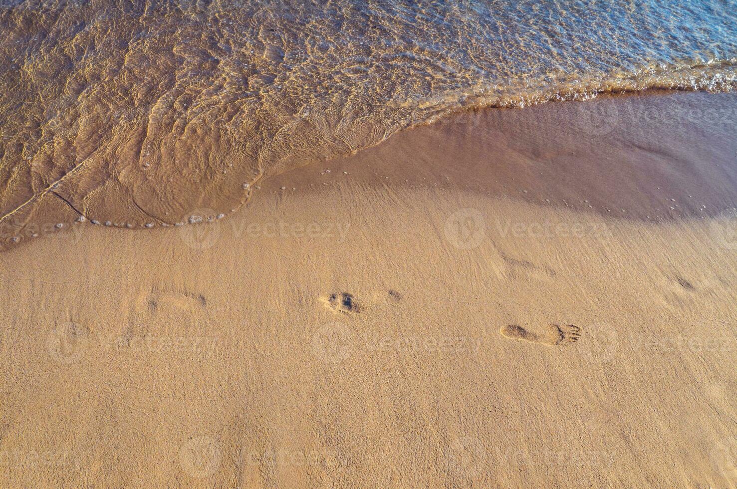 voetafdrukken Aan een leeg tropisch zanderig strand foto