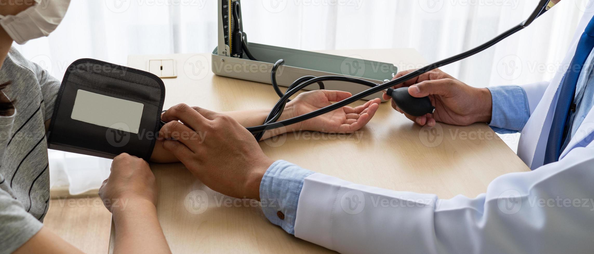 arts die bloeddrukmeter gebruikt om de bloeddruk van de patiënt te meten foto