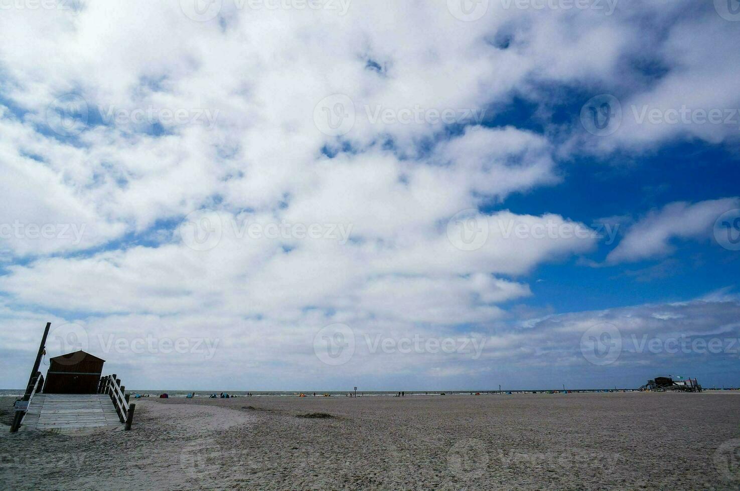 een badmeester toren Aan een zanderig strand met wolken in de lucht foto