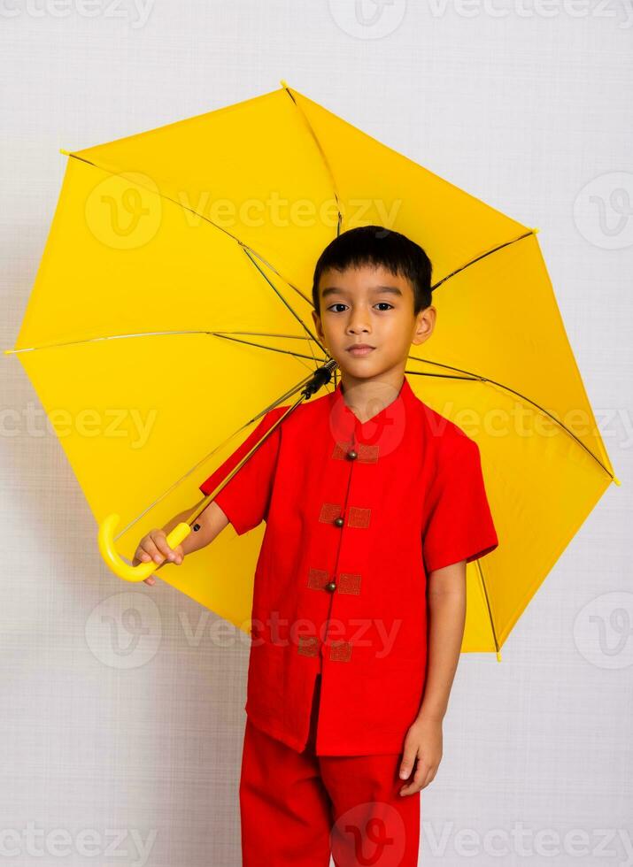 weinig jongen mode glimlachen kind in rood Chinese jurk, stijl en mode ideeën voor kinderen. Chinese nieuw jaar foto