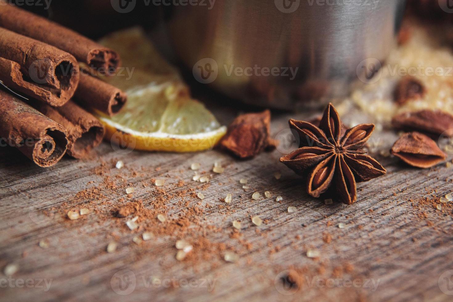 Glühwein in een kopje met kaneel, citroen op een houten rusric bord foto