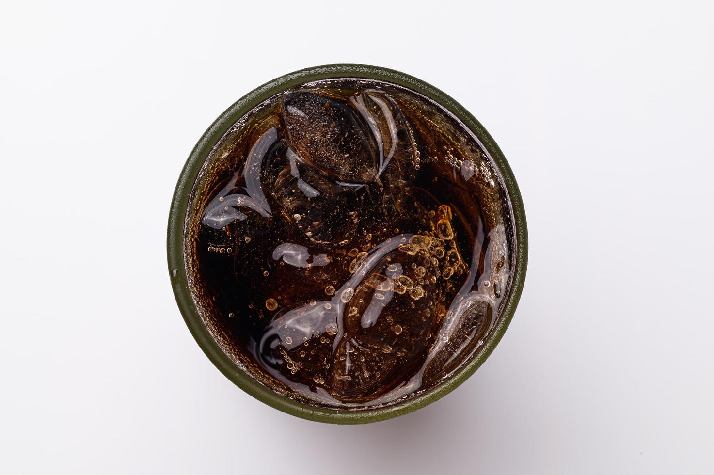 cola in glas met heldere ijsblokjes geïsoleerd op witte achtergrond foto