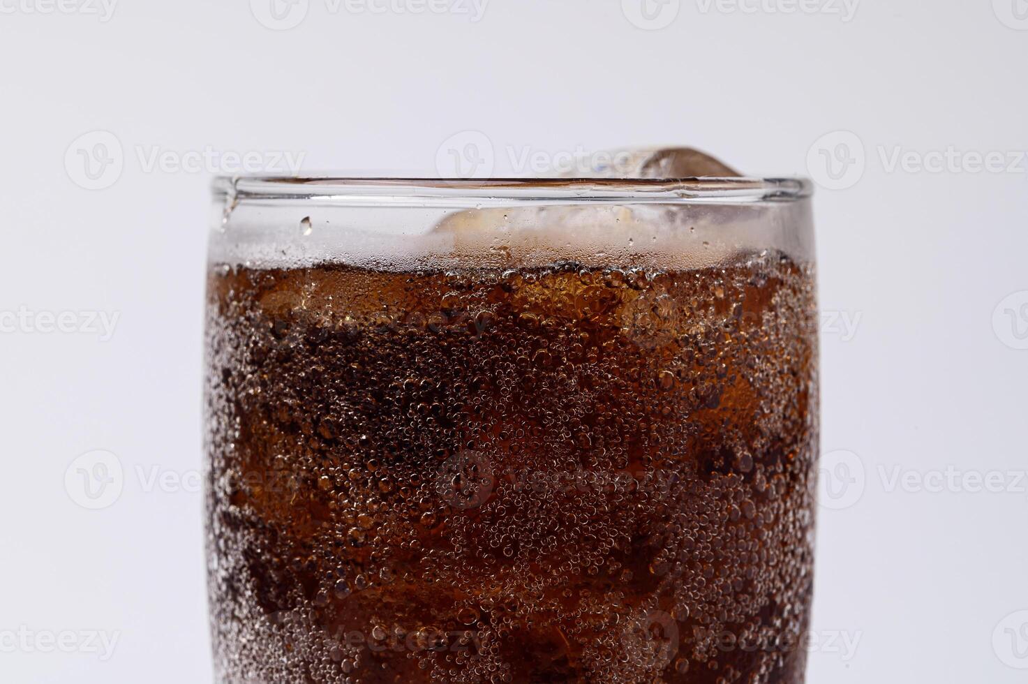 cola in glas met heldere ijsblokjes geïsoleerd op witte achtergrond foto