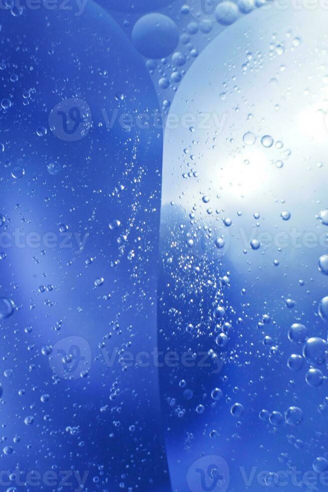 olie bubbels dichtbij omhoog. cirkels van water macro. abstract licht blauw achtergrond foto