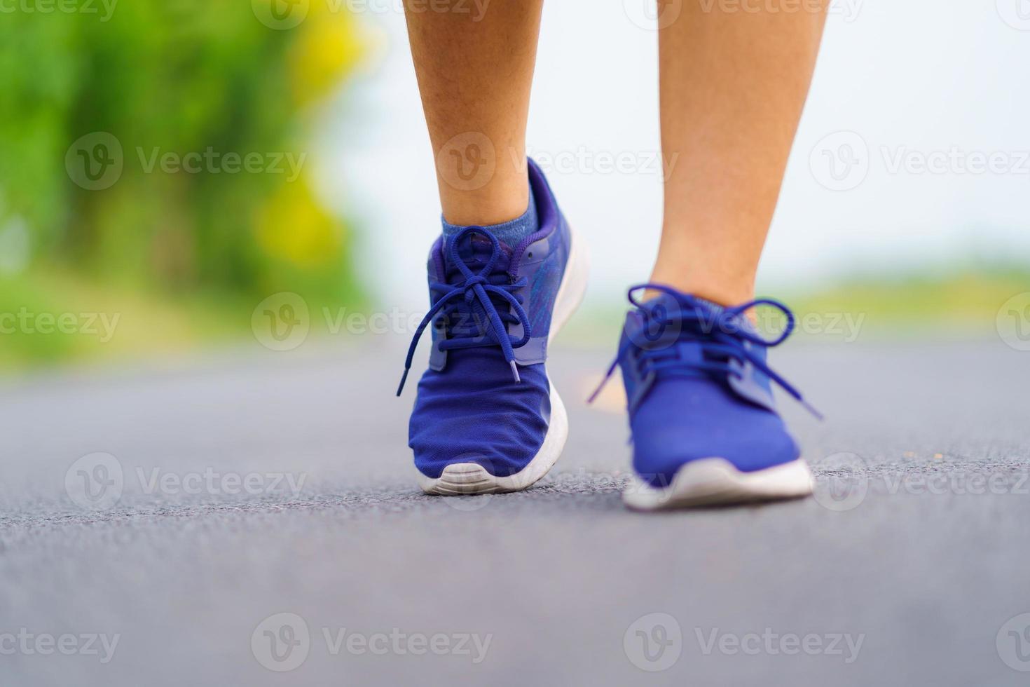 vrouw voeten lopen op de weg, gezonde fitness vrouw training foto