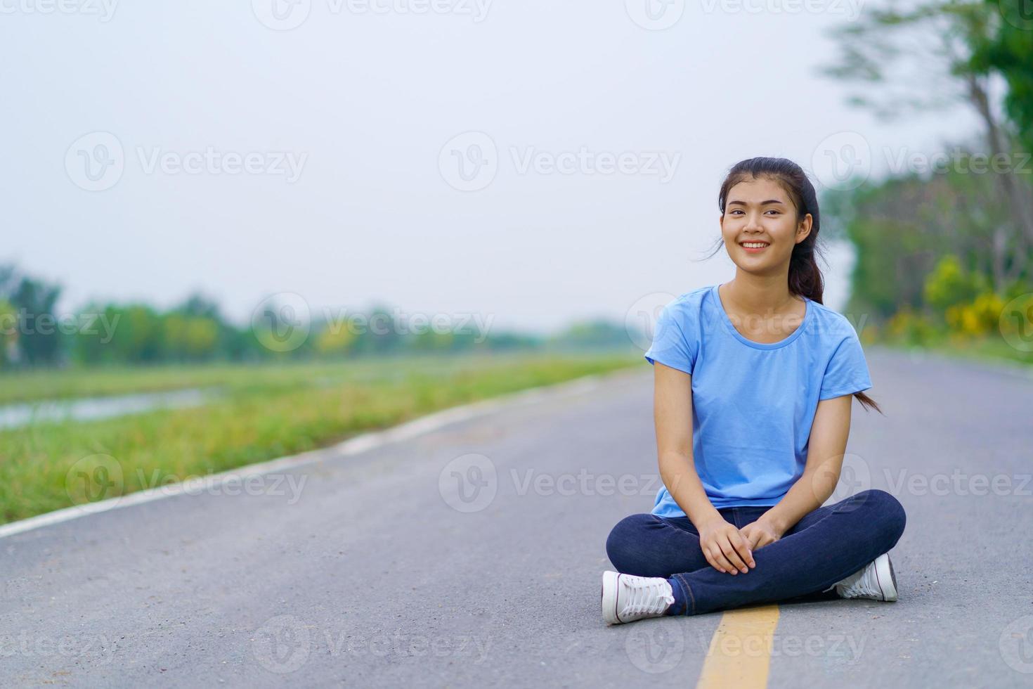 vrouw zittend op de weg in het park foto