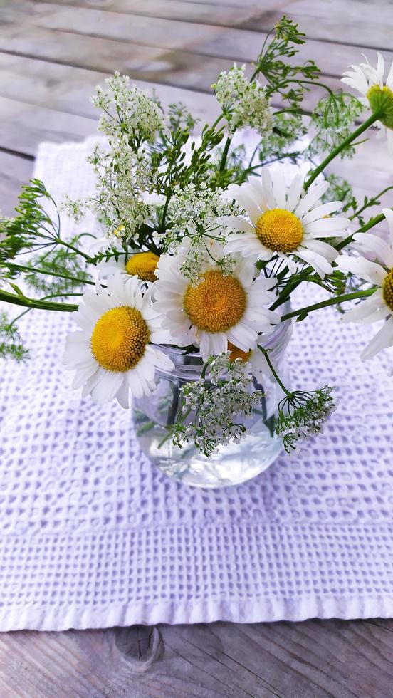 een boeket madeliefjes in een glazen pot, bovenaanzicht. bloemen foto