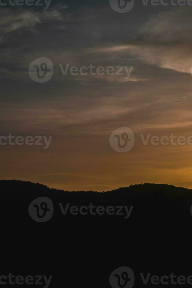 silhouet van een berg in de avond foto