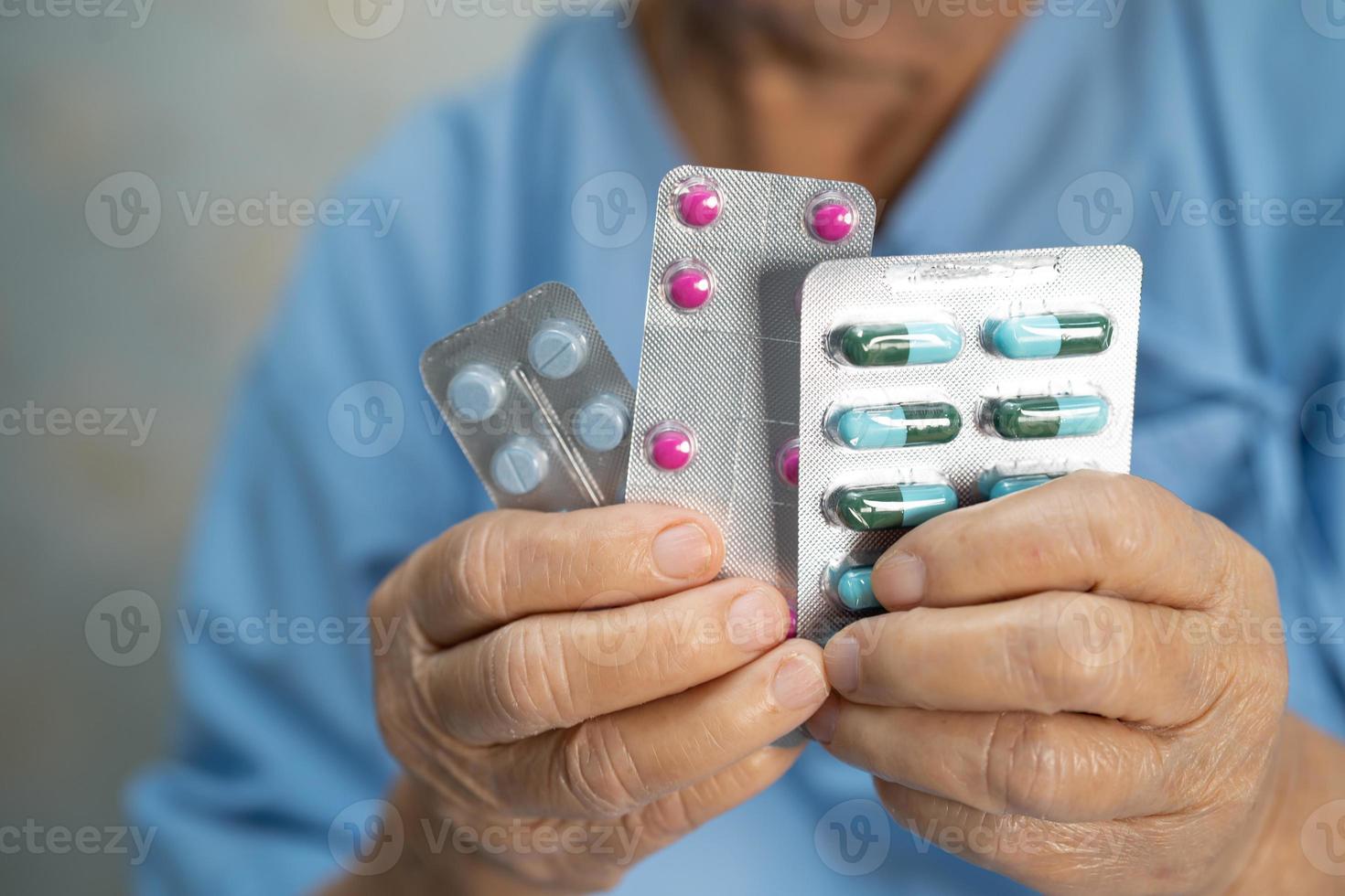 Aziatische senior vrouw patiënt met antibiotica capsule pillen i foto