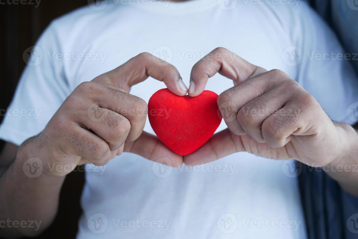 man met rood hart op blauwe achtergrond foto