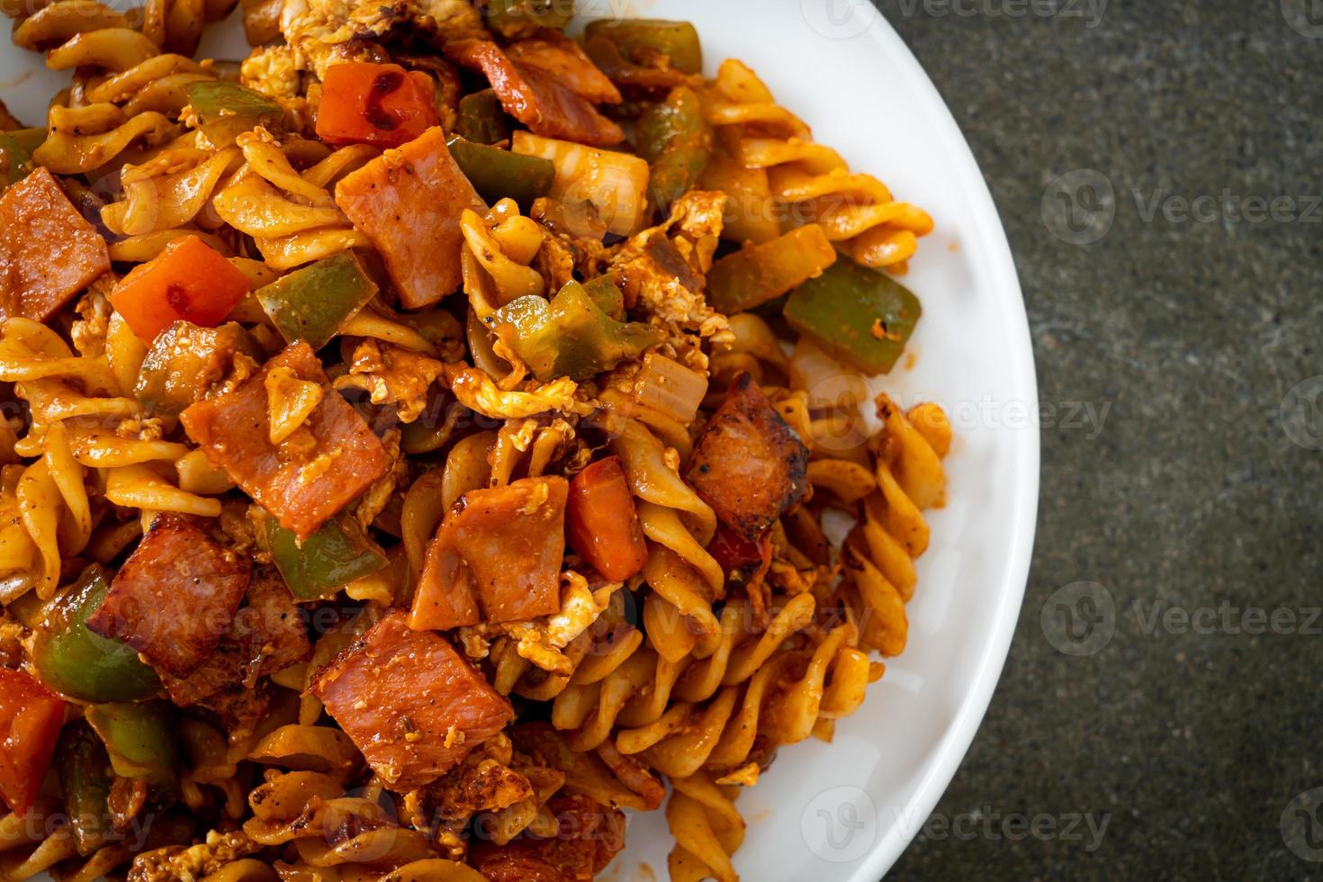 gewokte fusilli pasta met ham en tomatensaus foto