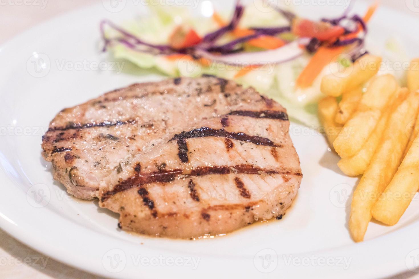 Oosterse varkenssteak op witte plaat foto