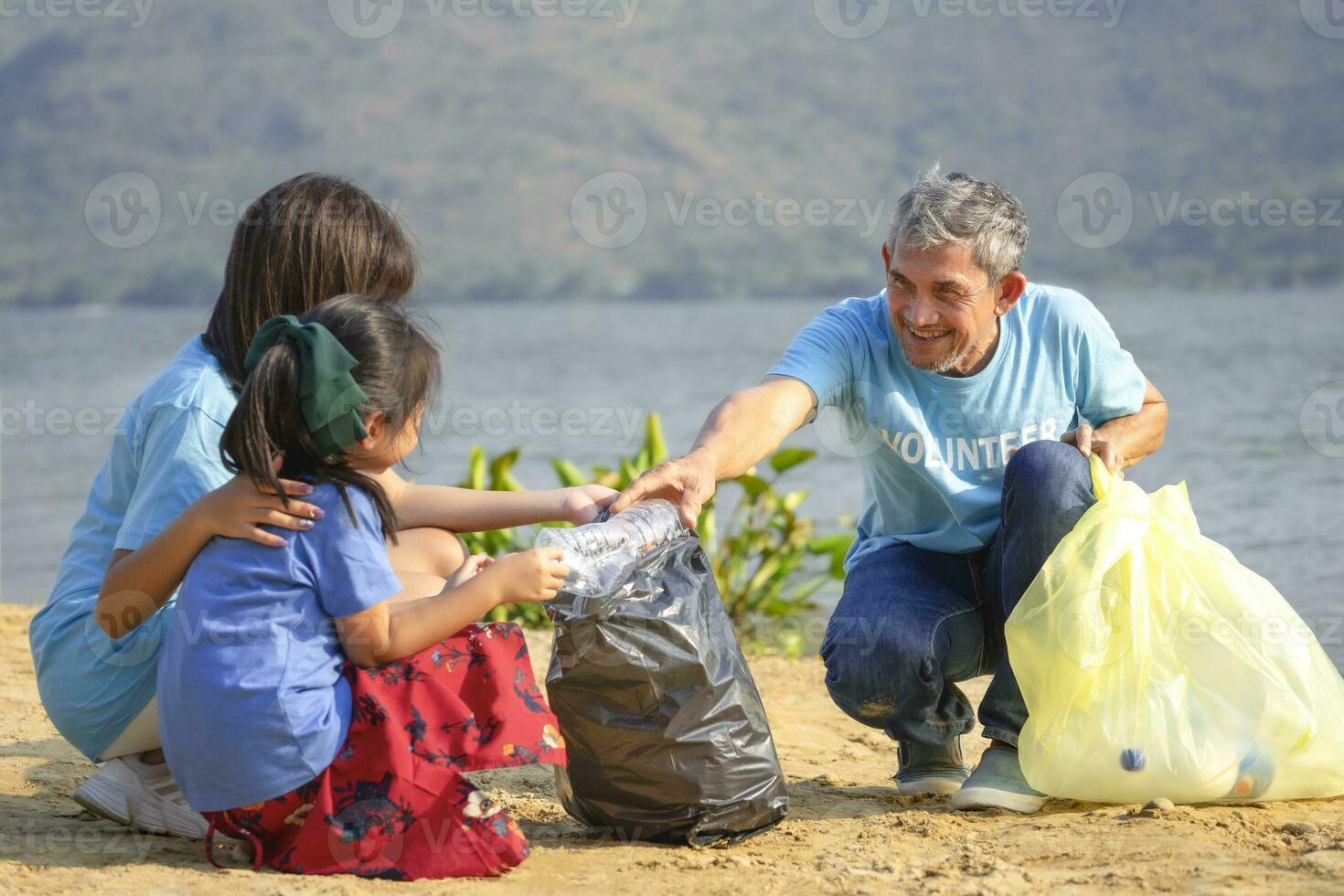 opa vrijwilliger houdt plastic fles onderwijzen kinderen naar scheiden vuilnis Bij zand strand, verzamelen en scheiden plastic fles voor hergebruik, concept van milieu natuurbehoud, campagne, bewustwording, ondersteuning foto