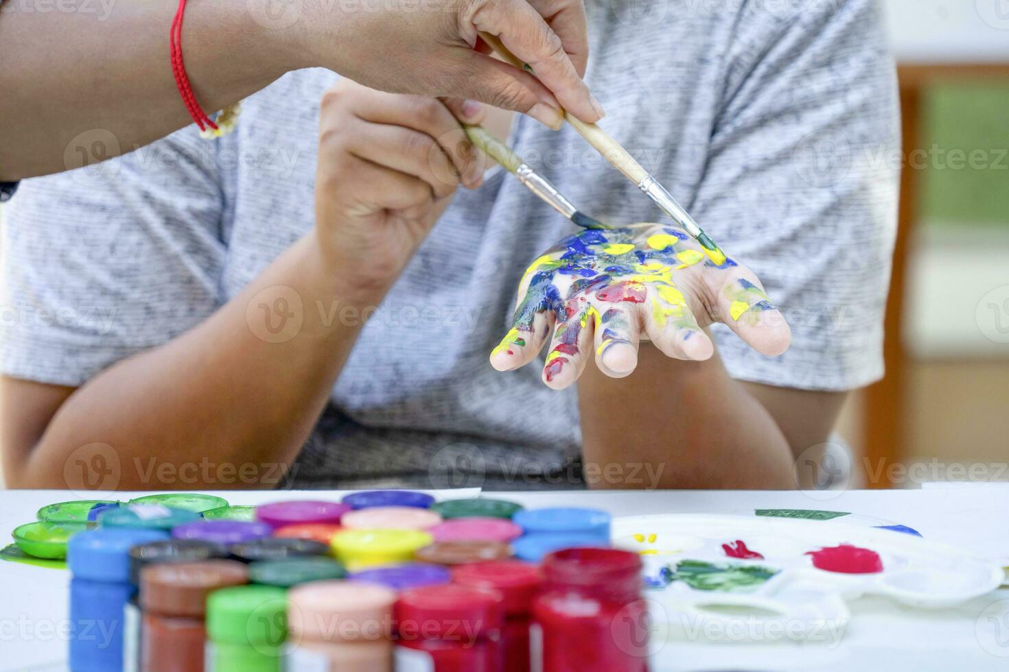 tiener- jongen genieten schilderij waterverf Aan zijn hand- Bij school- kunst club, concept van school- keuzevak activiteiten, kunst talent vermogen foto