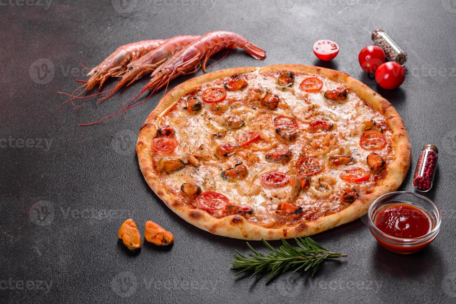 smakelijke gesneden pizza met zeevruchten en tomaat op een betonnen ondergrond foto