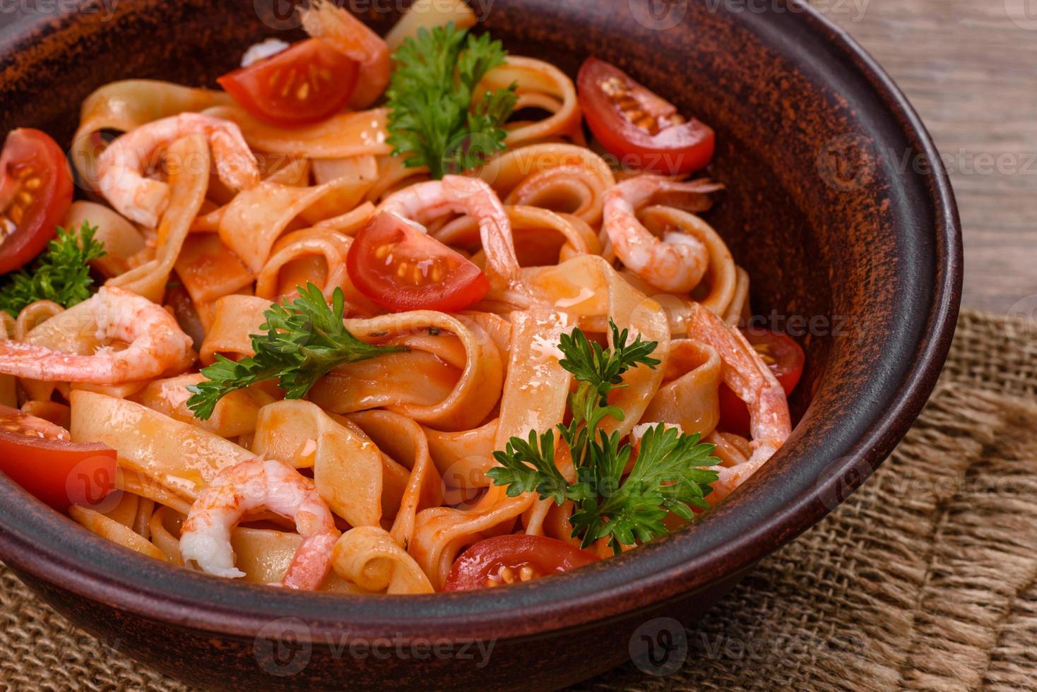 fettuccine pasta met garnalen, cherrytomaatjes, saus, specerijen en kruiden foto