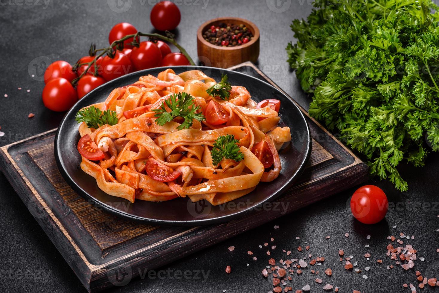 fettuccine pasta met garnalen, cherrytomaatjes, saus, specerijen en kruiden foto