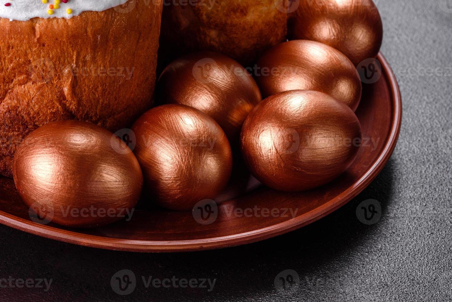 paaseieren goud en brons en paascake op een donkere achtergrond foto