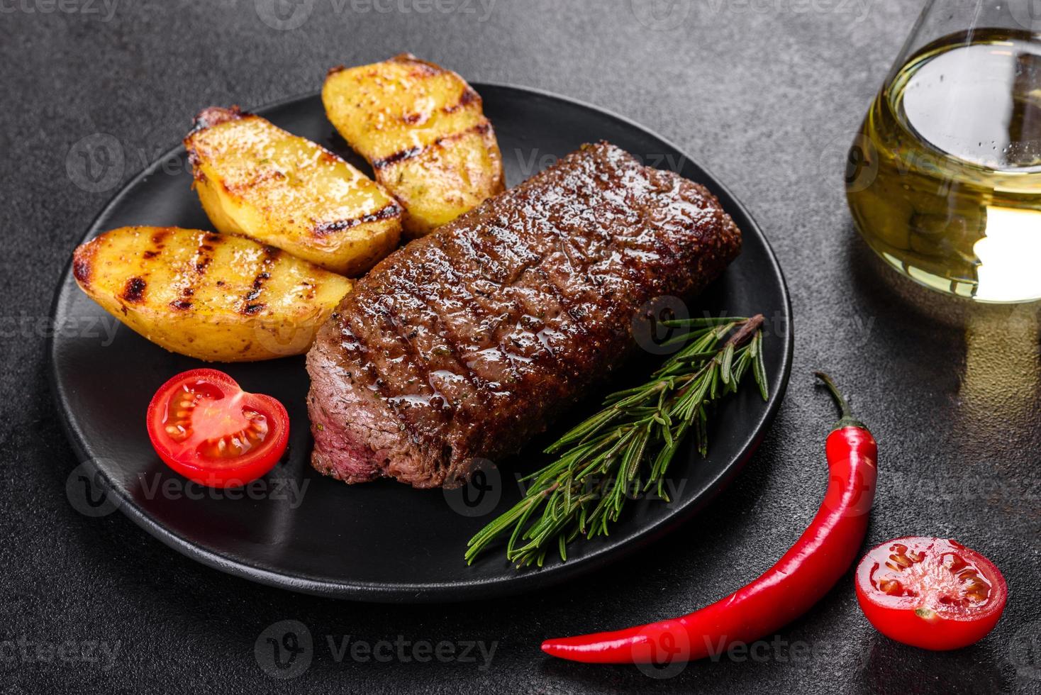 ribeye steak met aardappelen, uien en cherrytomaatjes foto