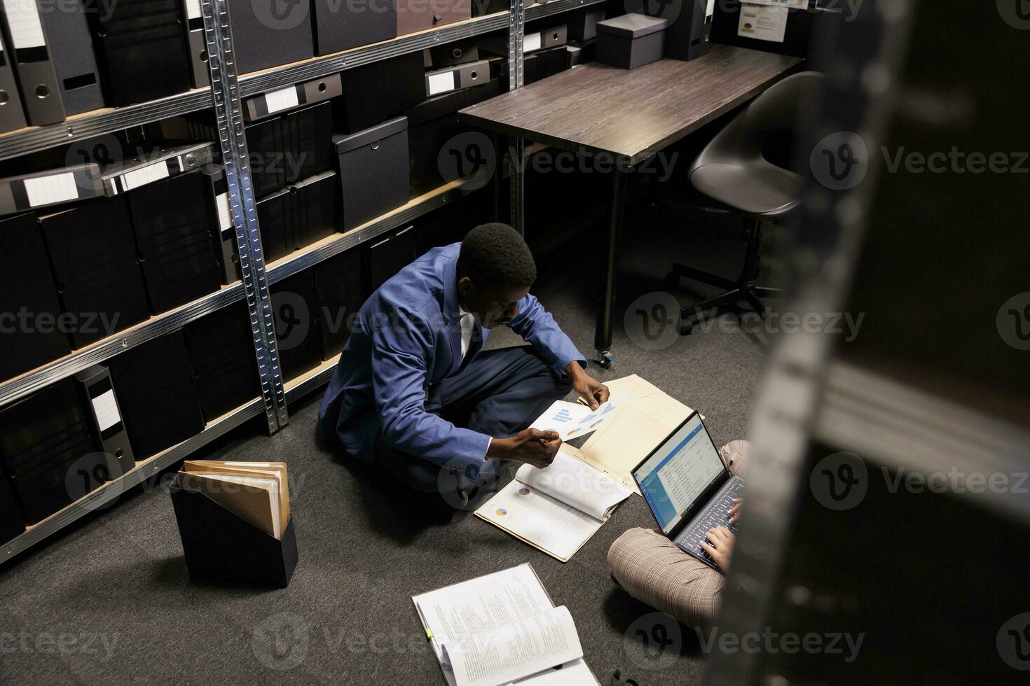 Afrikaanse Amerikaans inspecteur zoeken voor aanwijzingen, analyseren misdrijf tafereel bewijs in archiveren kamer. verschillend privaat detectives werken na een tijdje Bij crimineel onderzoek. wet handhaving concept foto