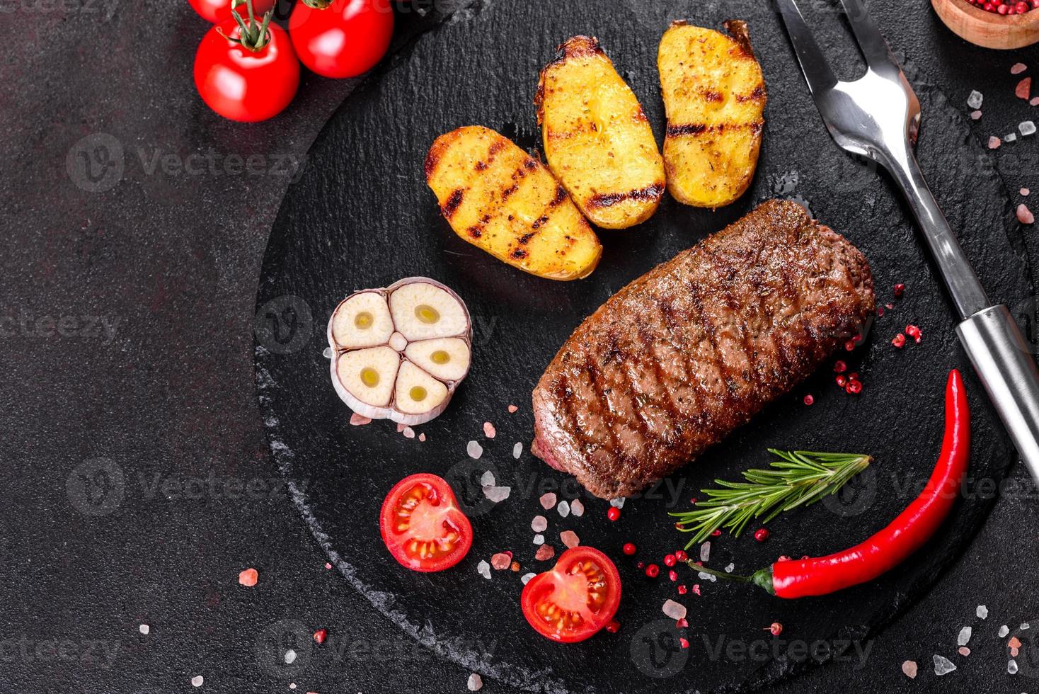 ribeye steak met aardappelen, uien en cherrytomaatjes foto