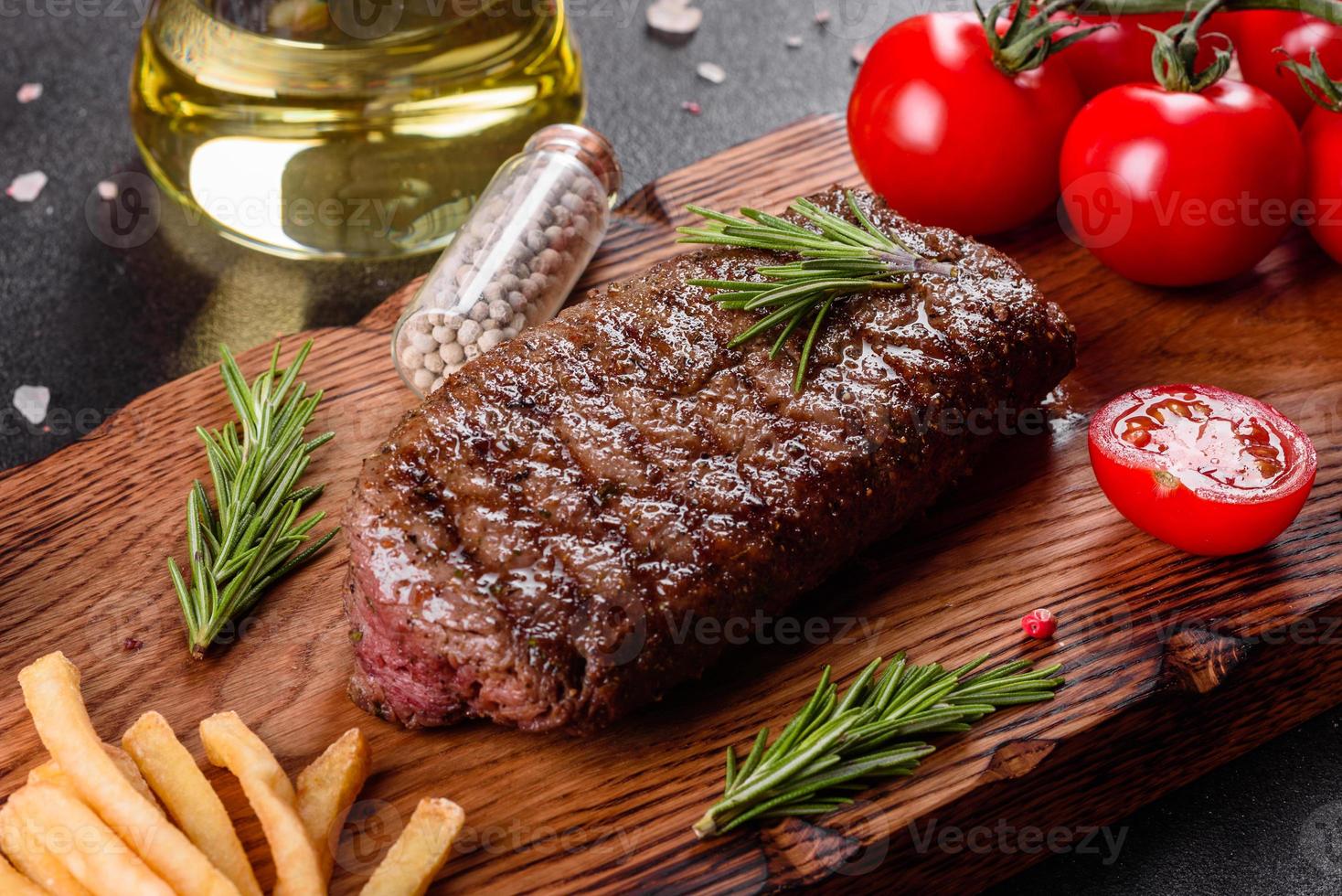 ribeye steak met aardappelen, uien en cherrytomaatjes foto