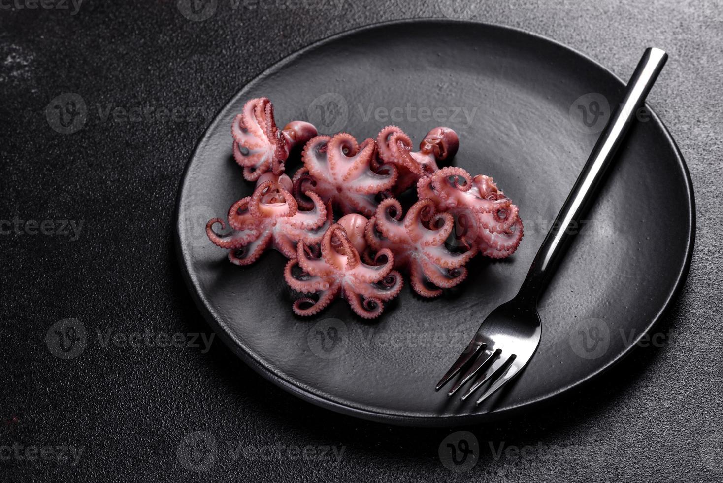 zeevruchten baby octopus salade in een zwarte plaat foto