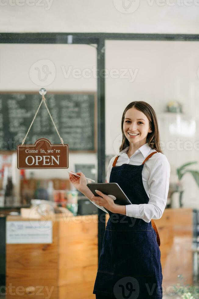 opstarten geslaagd klein bedrijf eigenaar mkb vrouw staan met tablet in cafe restaurant. foto