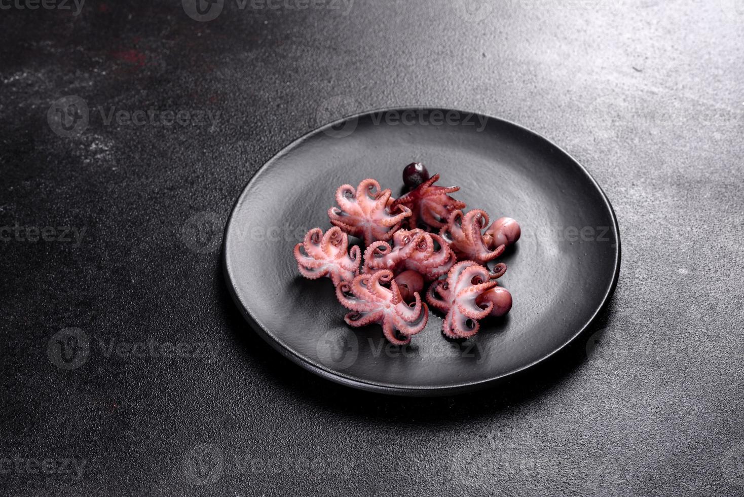 zeevruchten baby octopus salade in een zwarte plaat foto
