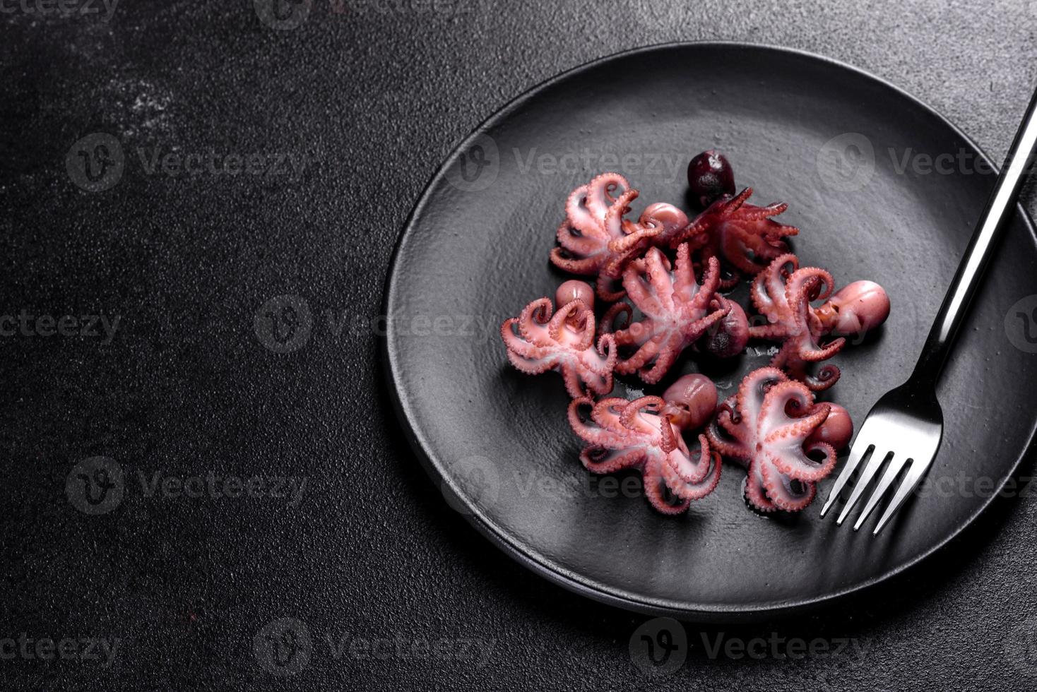 zeevruchten baby octopus salade in een zwarte plaat foto