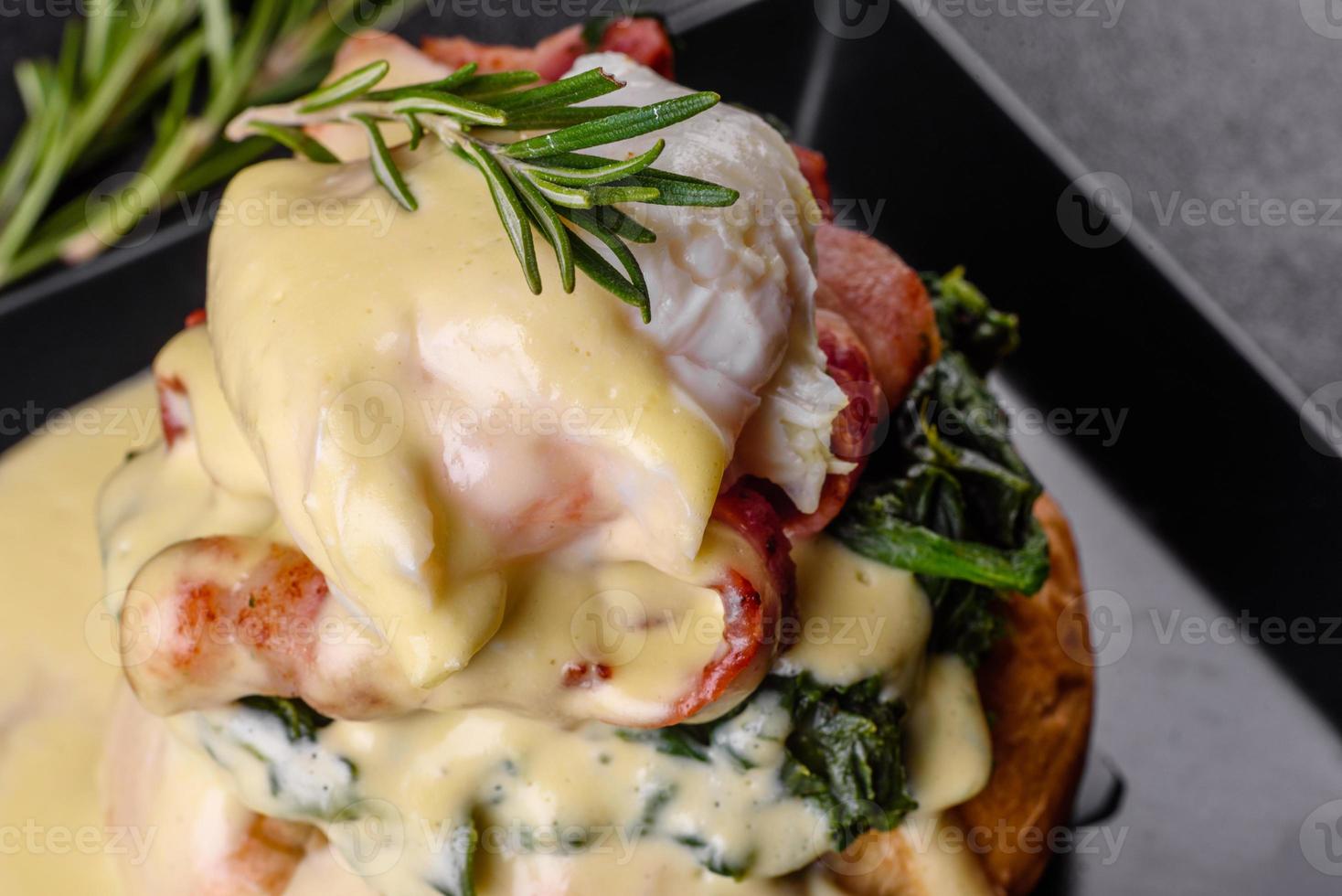 Eggs Benedict of Eggs Florentine op een zwarte plaat in het café foto