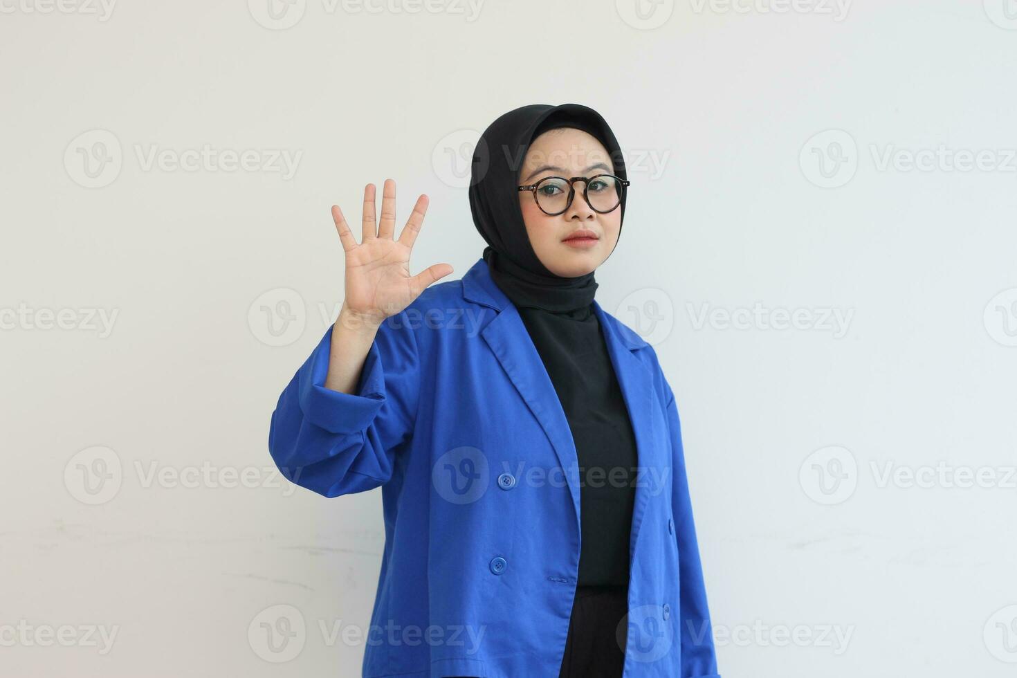 mooi jong Aziatisch moslim vrouw, vervelend bril en blauw blazer tonen palmen terwijl glimlachen foto