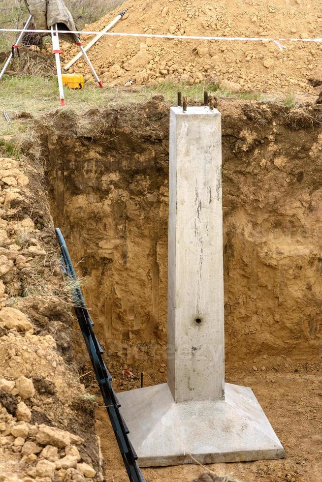 betonnen ondersteuning maakt deel uit van de fundering van metalen hoogspanningsondersteuning foto