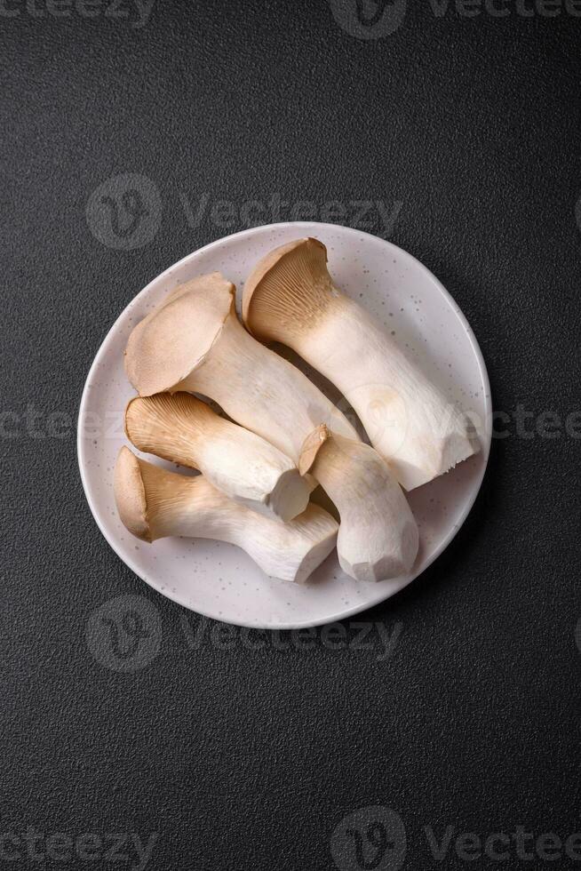 pleurotus eryngii champignons Aan een donker beton achtergrond foto