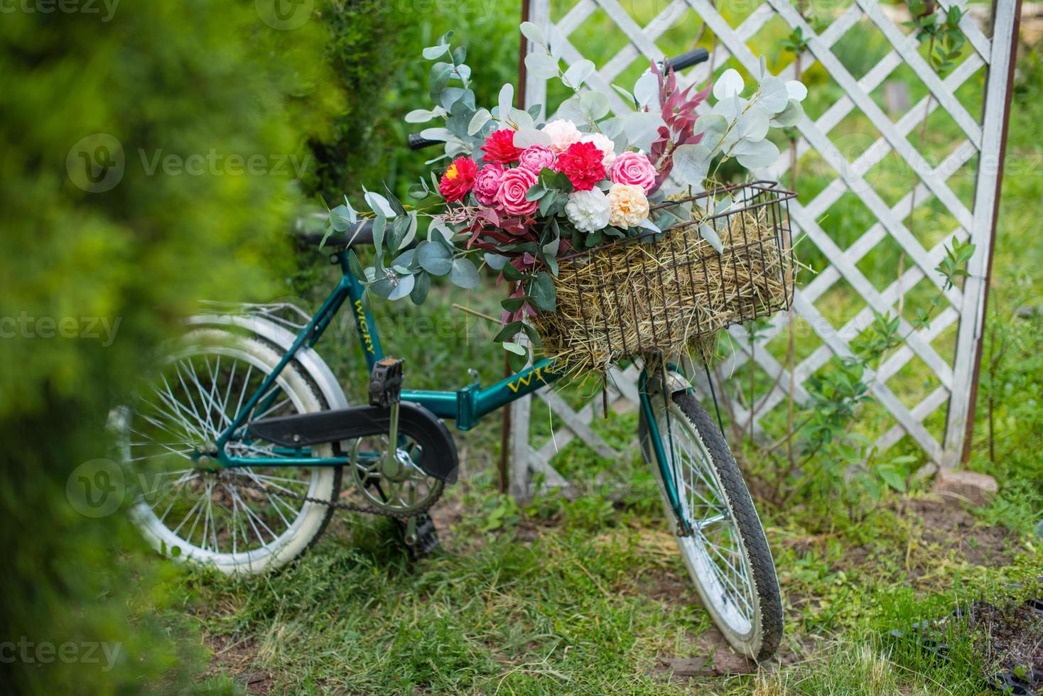 mooie fiets met bloemen in een mand staat op een laan foto