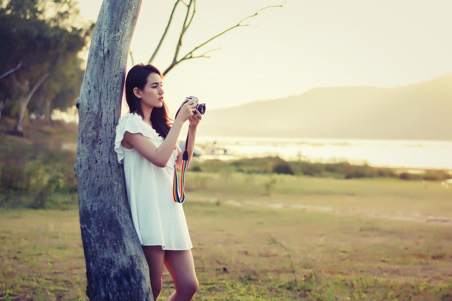 mooie vrouw fotograaf staande hand met retro camera foto