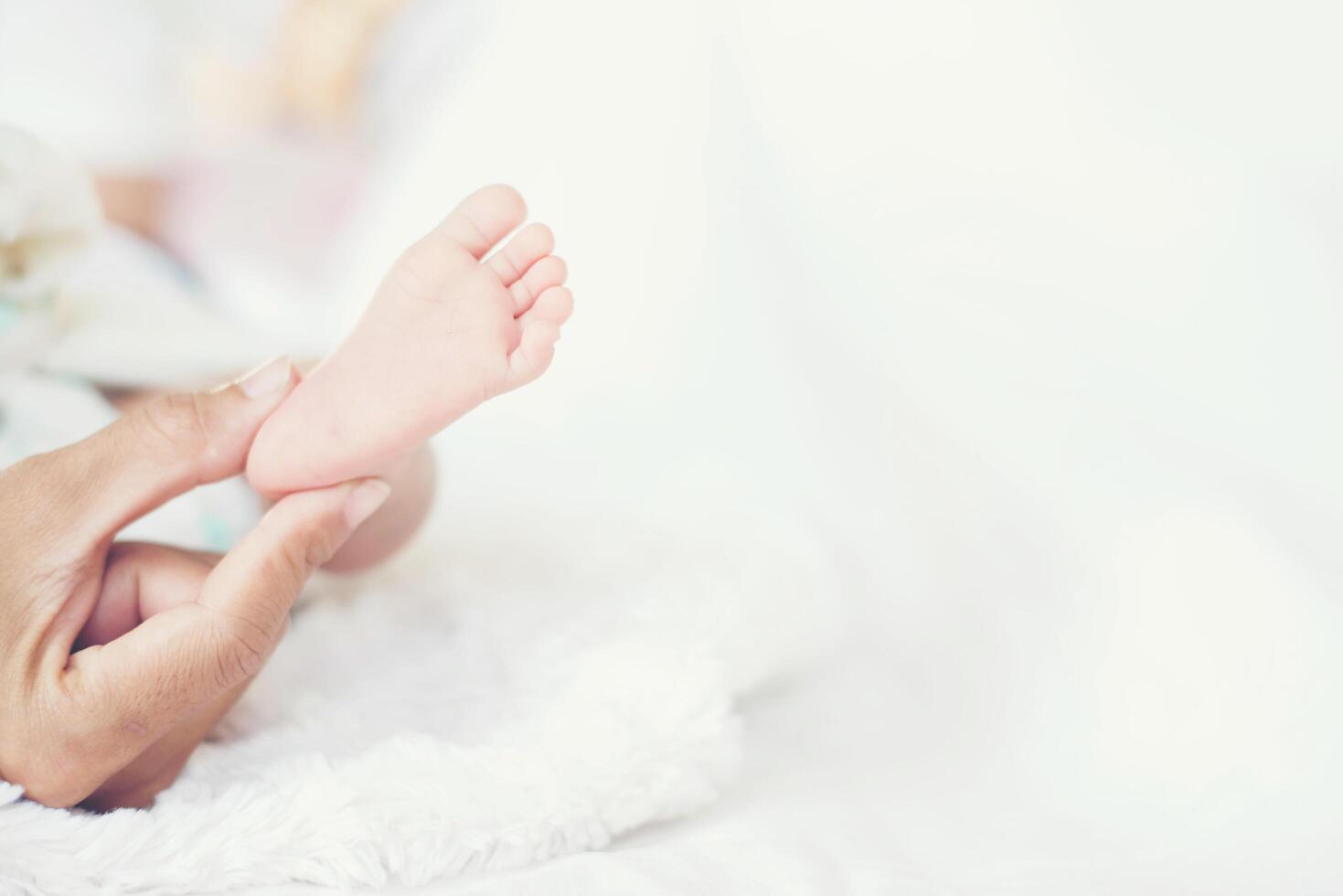 newbron baby voeten in de handen van de moeder. foto
