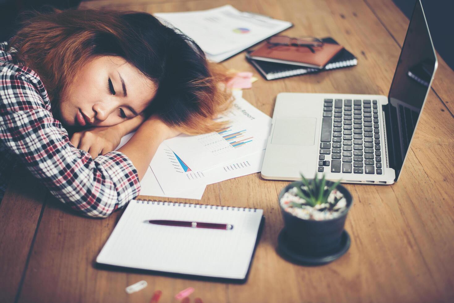 jonge hipster vrouw moe van het werk en dutje op de werkplek. foto