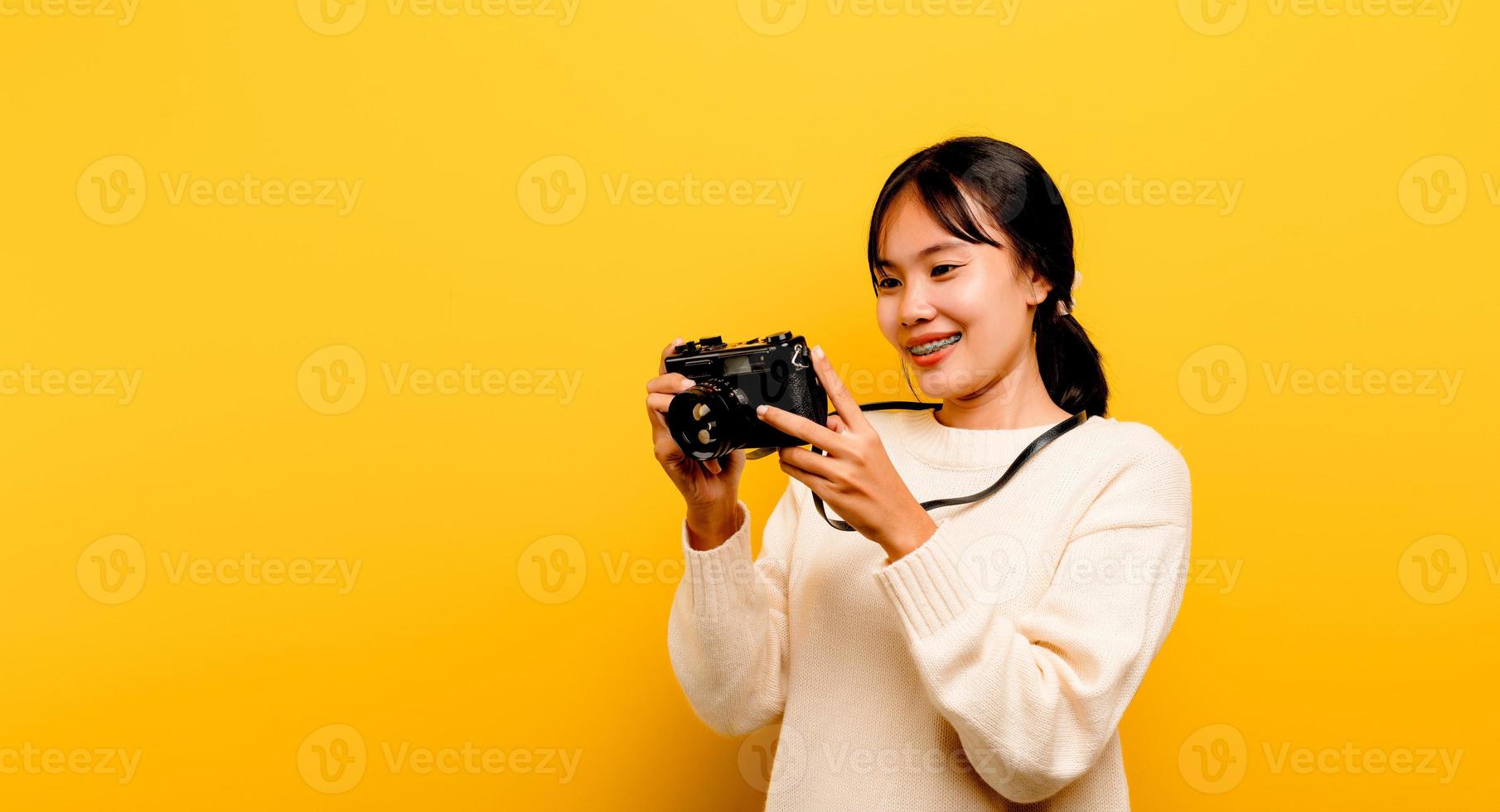 mooie jonge Aziatische toeristische studio-opname met camera foto