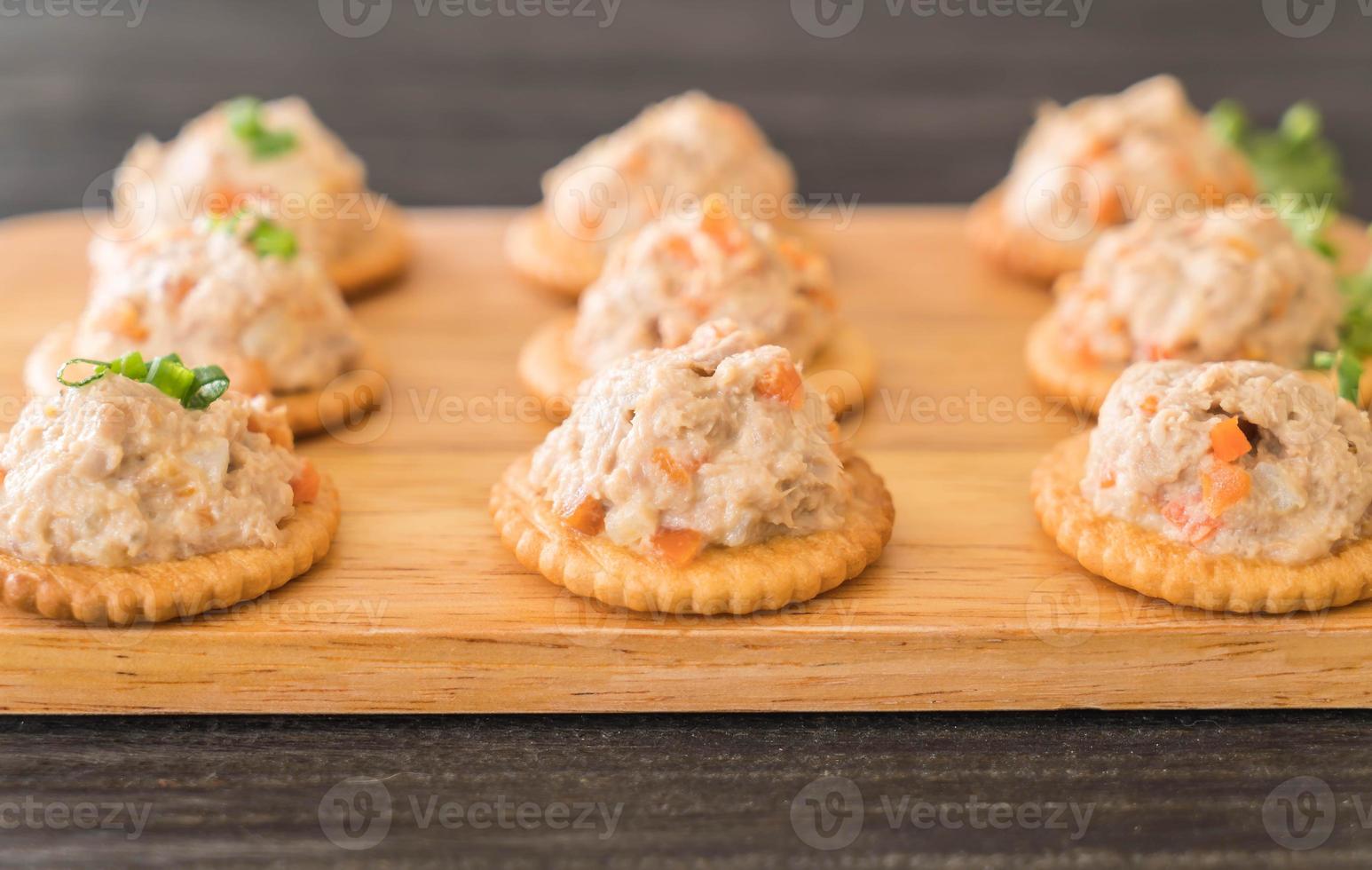 tonijnspread met cracker op houten bord foto