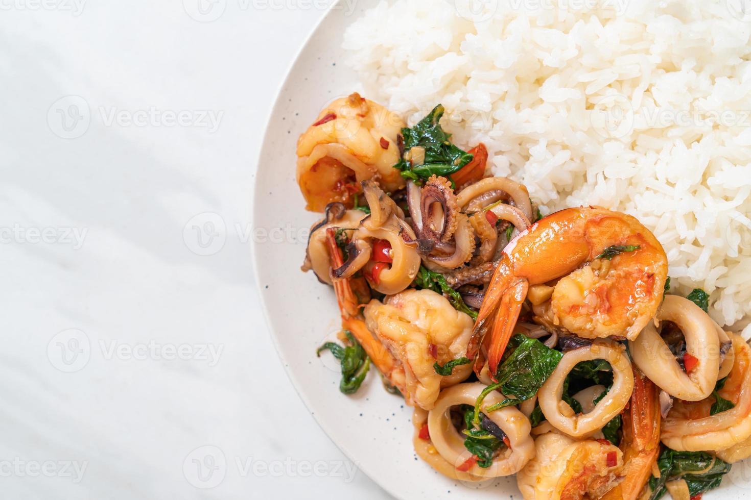 rijst en roergebakken zeevruchten van garnalen en inktvis met thaise basilicum - Aziatisch eten foto