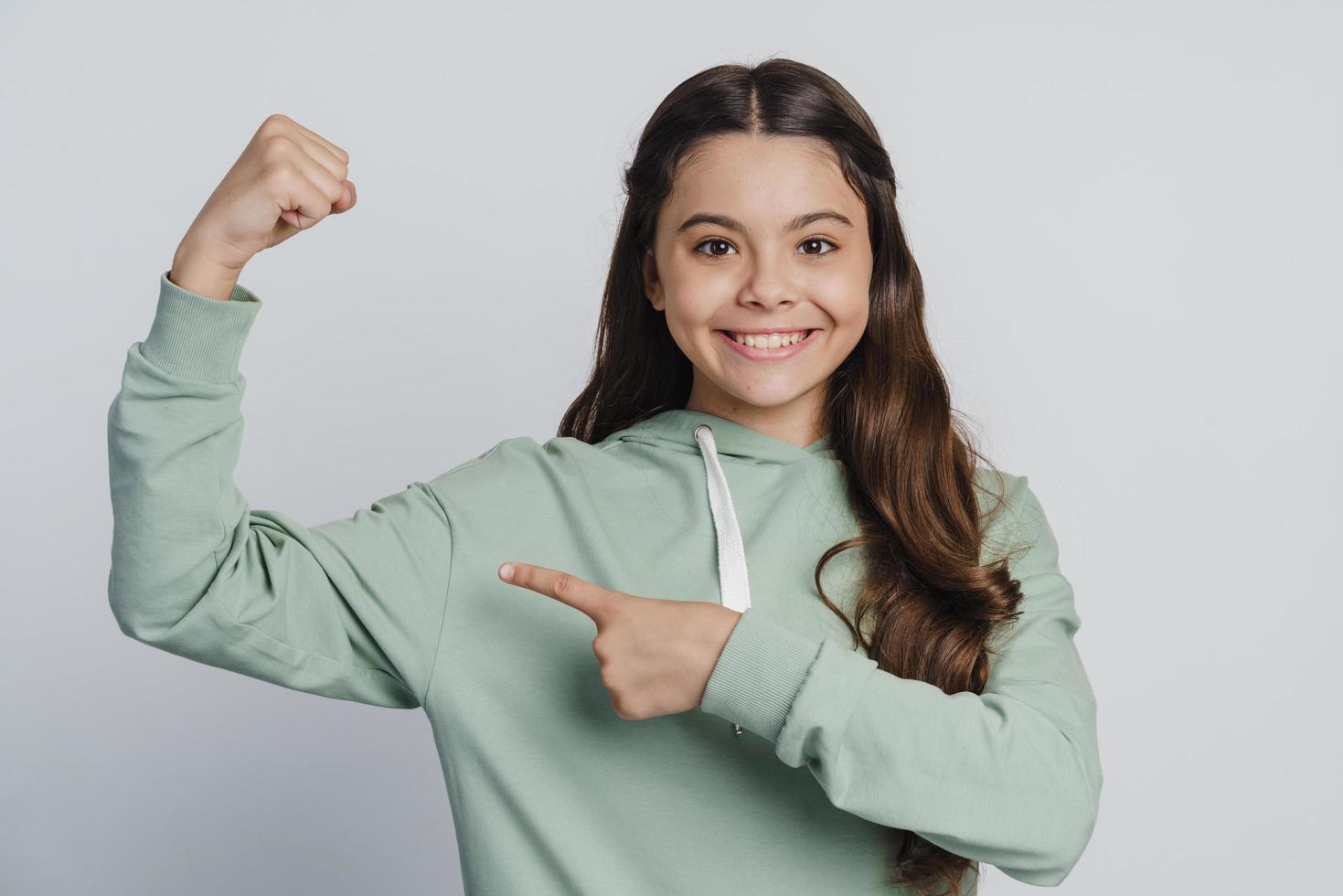 positief kind wijst een vinger naar de biceps foto