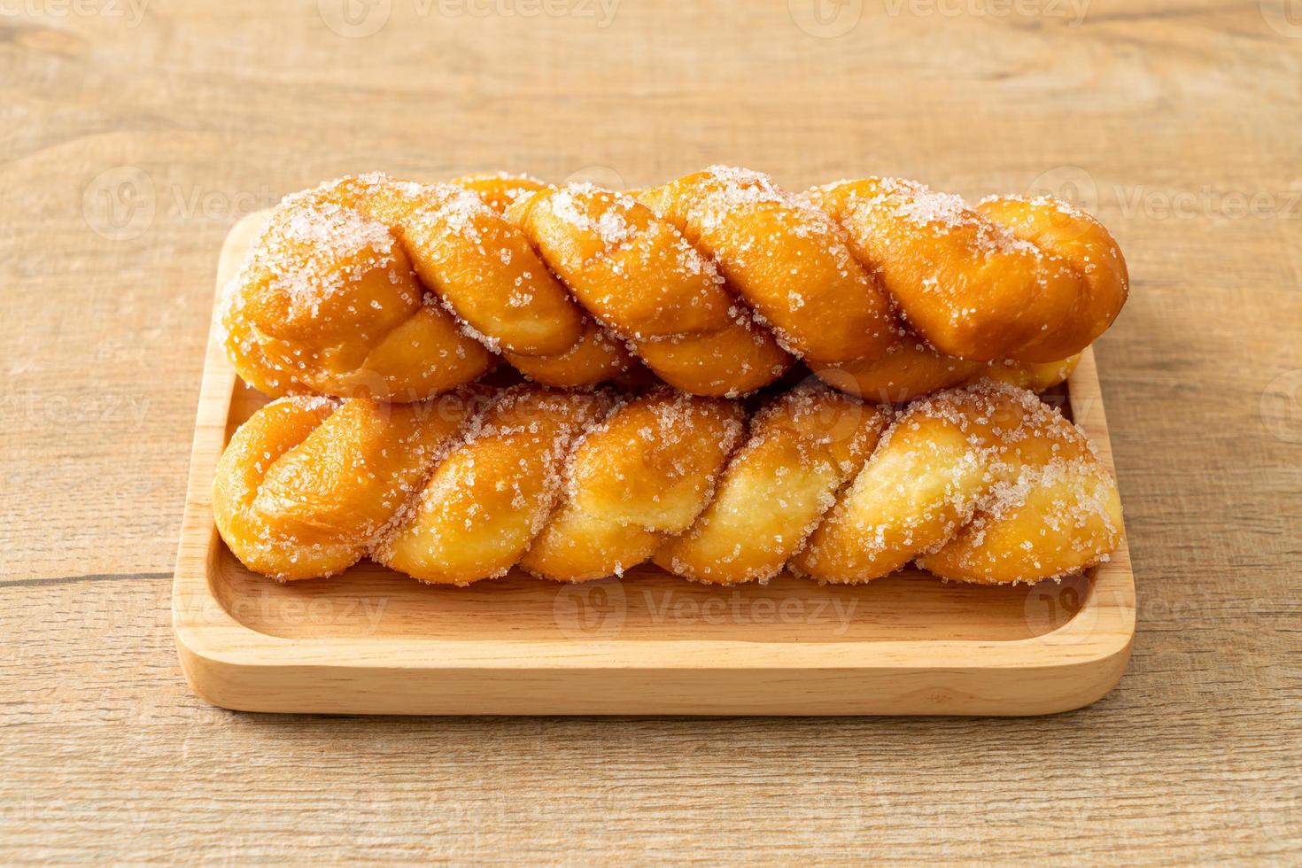 suiker donut in een spiraalvorm op houten plaat foto